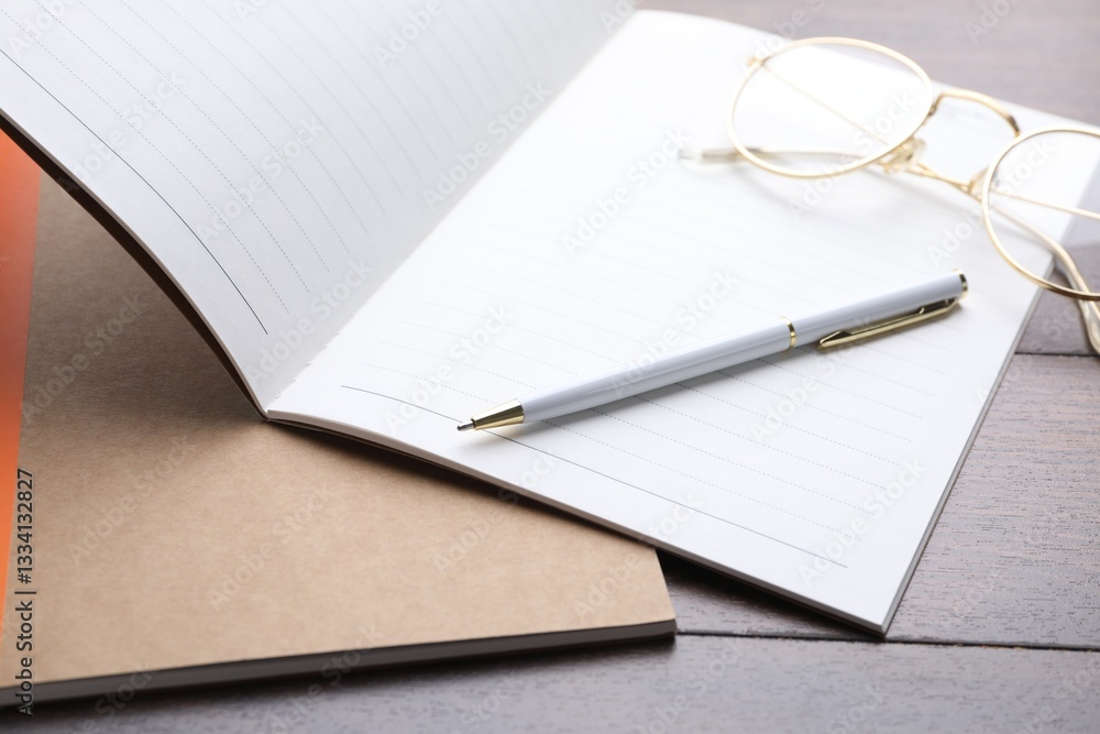 Copybooks, pen and glasses on wooden table, closeup Copybooks, pen and glasses on wooden table, closeup