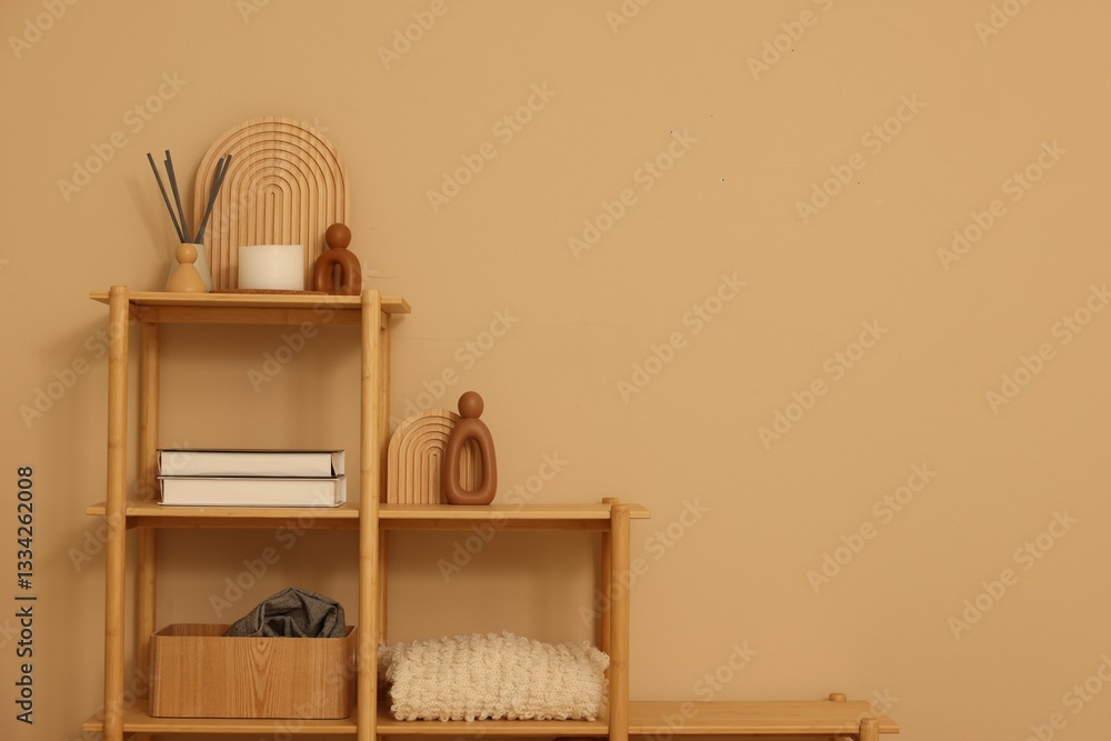 Obraz premium Shelving unit with decor near beige wall indoors, space for text