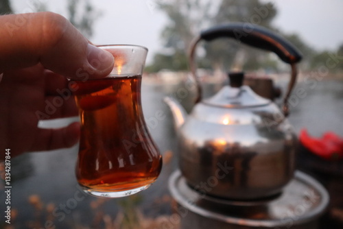Tableau sur toile Man is holding a glass of turkish tea in his hand