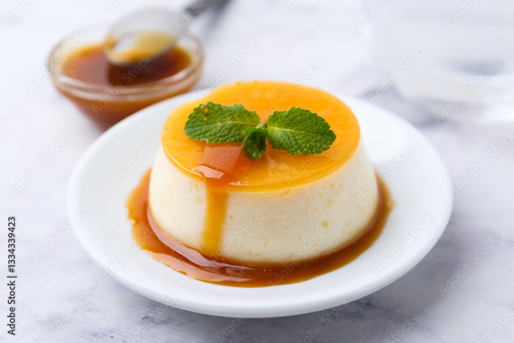 Tasty pudding with caramel sauce served on white marble table, closeup Tasty pudding with caramel sauce served on white marble table, closeup