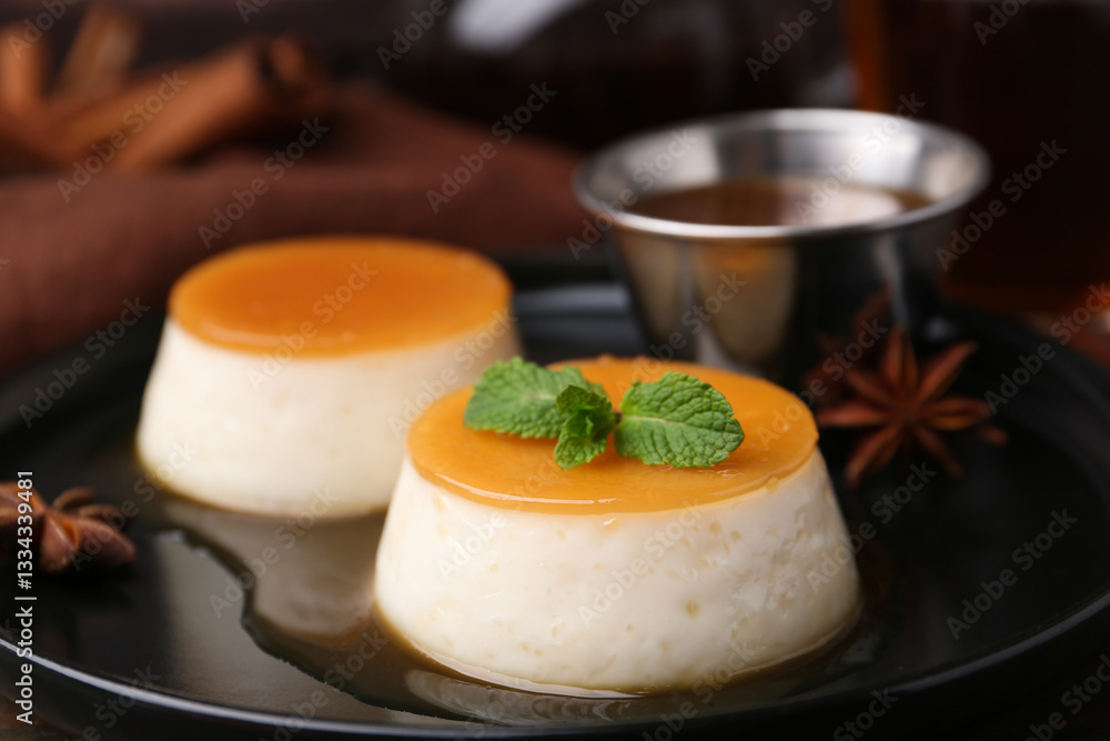 Tasty puddings with caramel sauce served on table, closeup Tasty puddings with caramel sauce served on table, closeup