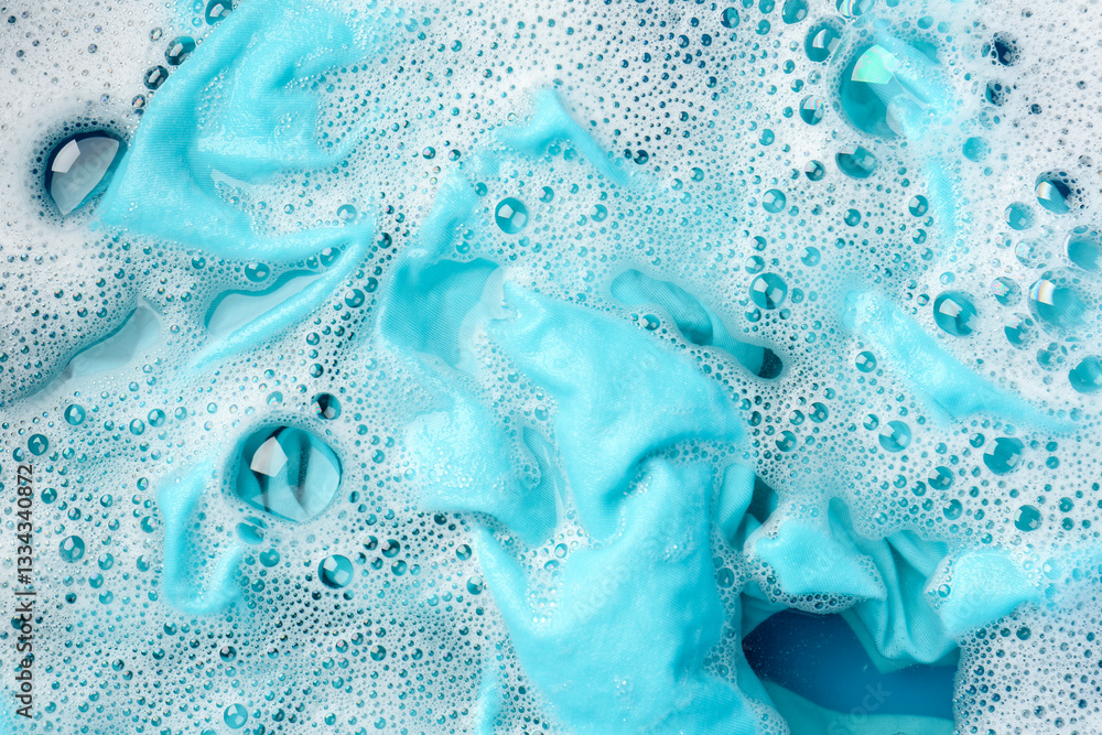 Turquoise clothes soaked in water before washing, top view Turquoise clothes soaked in water before washing, top view