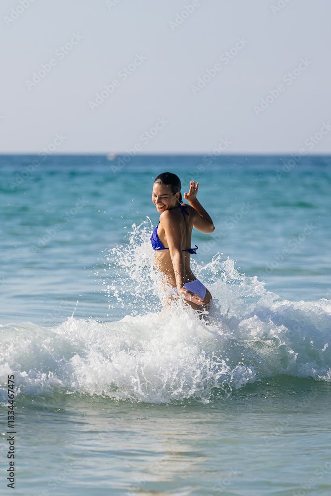A happy woman enjoys swimming in the ocean among large waves. Concept of travel, leisure, and relaxation. A happy woman enjoys swimming in the ocean among large waves. Concept of travel, leisure, and relaxation.
