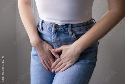 Female health concept. Woman hands holding crotch suffering from pain, burning, itching symptoms of cystitis, thrush, bacterial vaginosis or gynecological conditions.