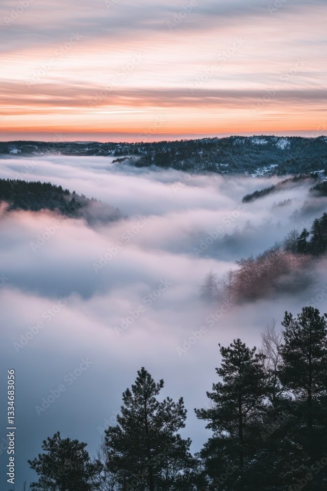 Fototapeta premium Fog envelops mountains at dawn in winter