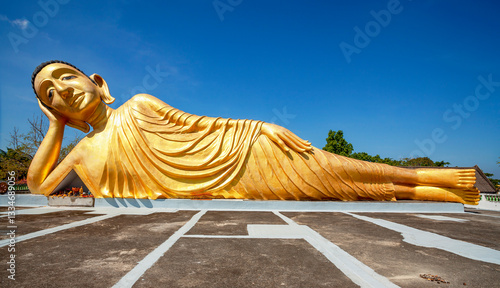 Obraz na płótnie Lying golden Buddha statue in Wat Sri Sunthon temple on Phuket in Thailand. Gilded Buddha statue in Phuket, Thailand. Famous tourist place in Phuket. w salonie