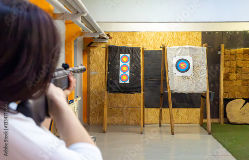 woman with long hair at shooting range shooting at target, selective focus on target