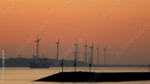 Wind turbines at Europoort at sunset, seagulls flying, Rotterdam, Netherlands