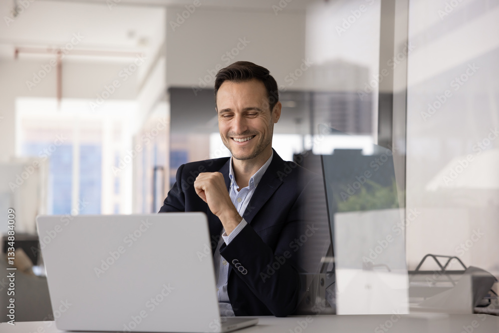 Happy business executive man working at computer at office workplace, typing, laughing, using job application, software, web service for online communication. Candid shot with copy space Happy business executive man working at computer at office workplace, typing, laughing, using job application, software, web service for online communication. Candid shot with copy space
