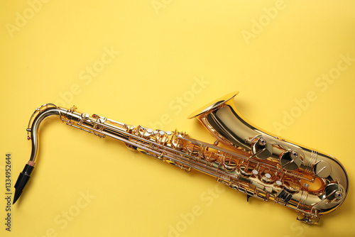 Photography Jazz. One saxophone on yellow background, top view