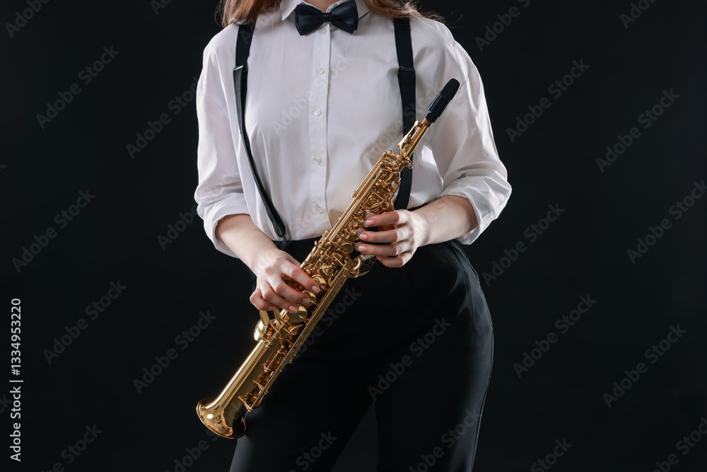 Naklejka premium Musician with soprano saxophone on dark background, closeup