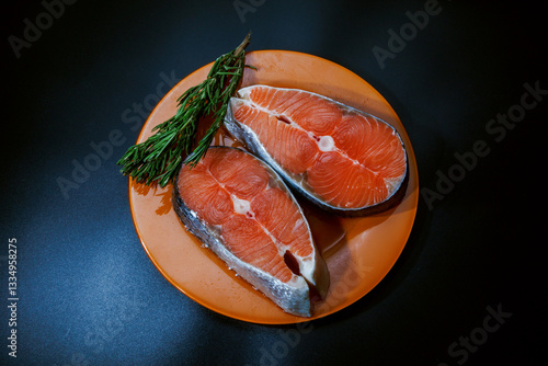 Raw salmon steaks with rosemary sprigs for grilling or baking