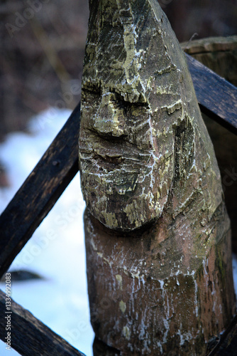 A wooden idol covered in moss.