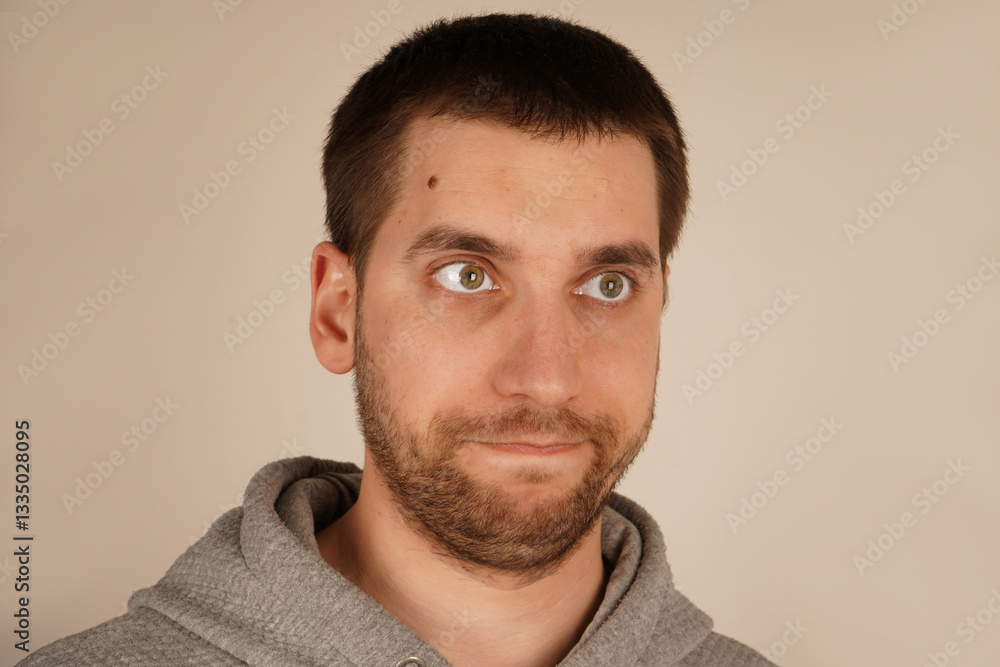 Obraz premium His facial features are tense, clearly expressing his aversion or repulsion to something he finds unpleasant. In this close-up, a young man s face displays a disgusted expression, with his eyes closed