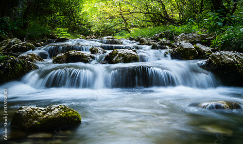 Flowing Stream Water Cascading Over Rocks in a Forest Setting