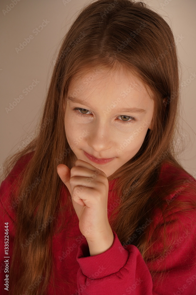 Her expression conveys a sense of ease as she takes a peaceful moment. The pose highlights her serenity. The little girl rests her chin on her clenched fist, looking relaxed and calm. Her expression conveys a sense of ease as she takes a peaceful moment. The pose highlights her serenity. The little girl rests her chin on her clenched fist, looking relaxed and calm.