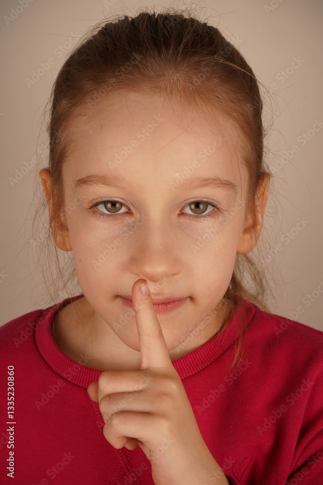 Her expression is firm yet kind, reinforcing the signal. A subtle way to convey stillness and attention. The girl gestures silence with her finger pressed to her lips. Her expression is firm yet kind, reinforcing the signal. A subtle way to convey stillness and attention. The girl gestures silence with her finger pressed to her lips.
