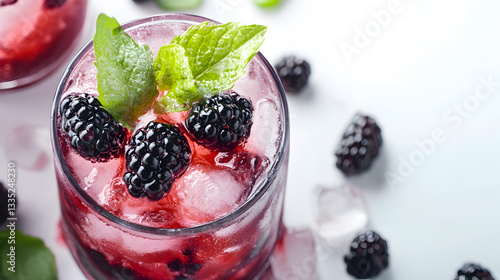 A glass of blackberry juice with a sprig of mint on top. The juice is cold and refreshing, perfect for a hot summer day