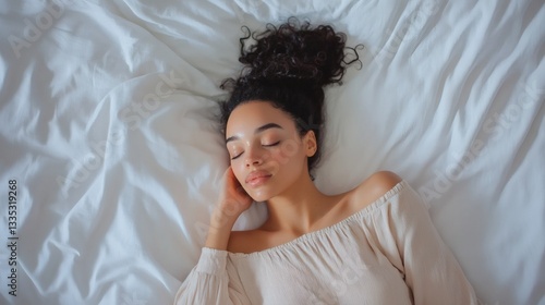 A beautiful woman asleep comfortably on a white bed peacefully photo