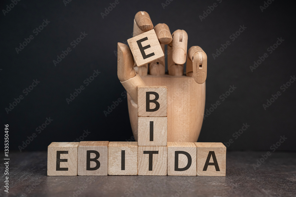 sztuczna ręka trzymająca kostkę z literą E tworząc napis EBIT I EBITDA na kostkach. Koncepcja oceny rentowności firmy