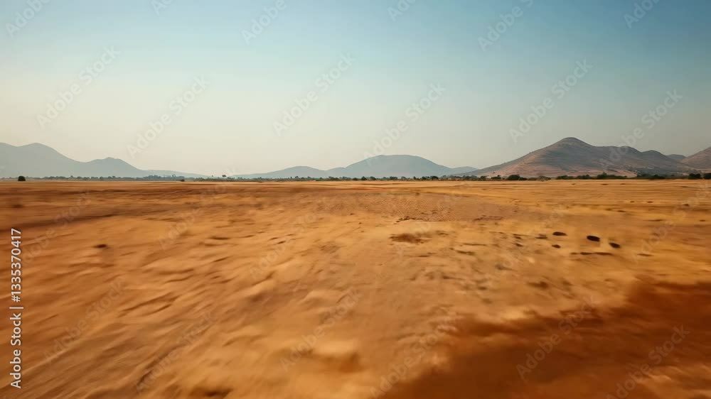 Vast desert landscape with golden sands stretching across the horizon, framed by distant mountains and a clear blue sky, showcasing the beauty and harshness of the arid environment.
Vast desert landscape with golden sands stretching across the horizon, framed by distant mountains and a clear blue sky, showcasing the beauty and harshness of the arid environment.