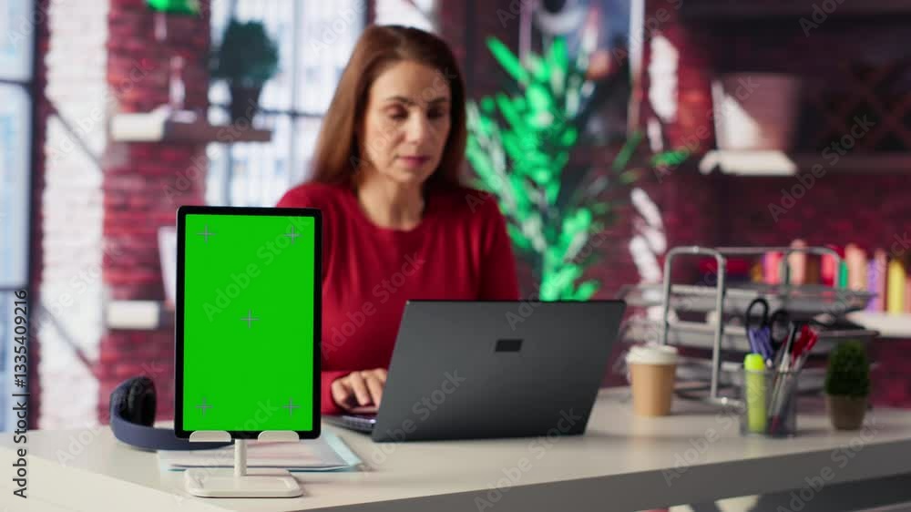 Person uses laptop for creative projects next to isolated copy space, creating designs while staying connected to the freelance platform. Woman focusing on research and multitasking. Camera A. Person uses laptop for creative projects next to isolated copy space, creating designs while staying connected to the freelance platform. Woman focusing on research and multitasking. Camera A.