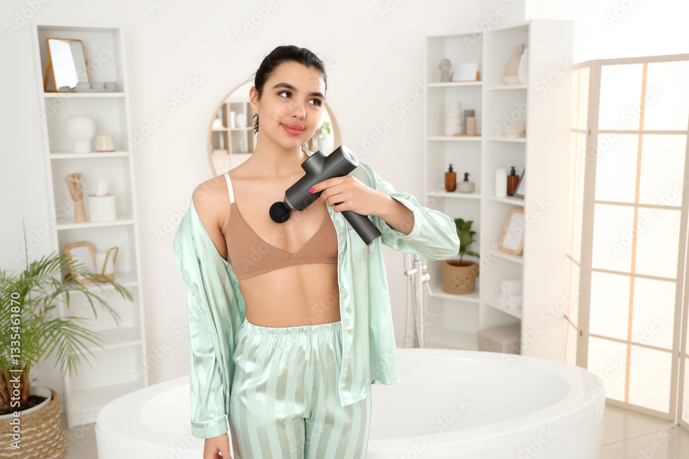 Young woman massaging her chest with percussive massager in bathroom Young woman massaging her chest with percussive massager in bathroom