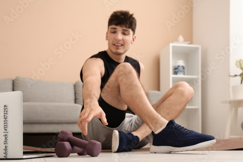 Sporty young man with dumbb...