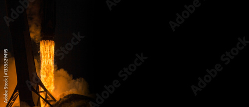 Fototapeta Naklejka Na Ścianę i Meble -  Rocket launch at night with fiery flames and smoke against a dark sky. Powerful engine burn during landing. Space shuttle rocket launch concept wallpaper. Elements of this image furnished by NASA