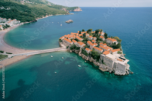 Foto White boats are moored near the isthmus of the island of Sveti Stefan in the Bay of Kotor
