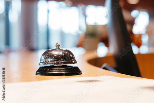 A shiny call bell inviting interaction and symbolizing immediate assistance beckons from a warm wood surface photo