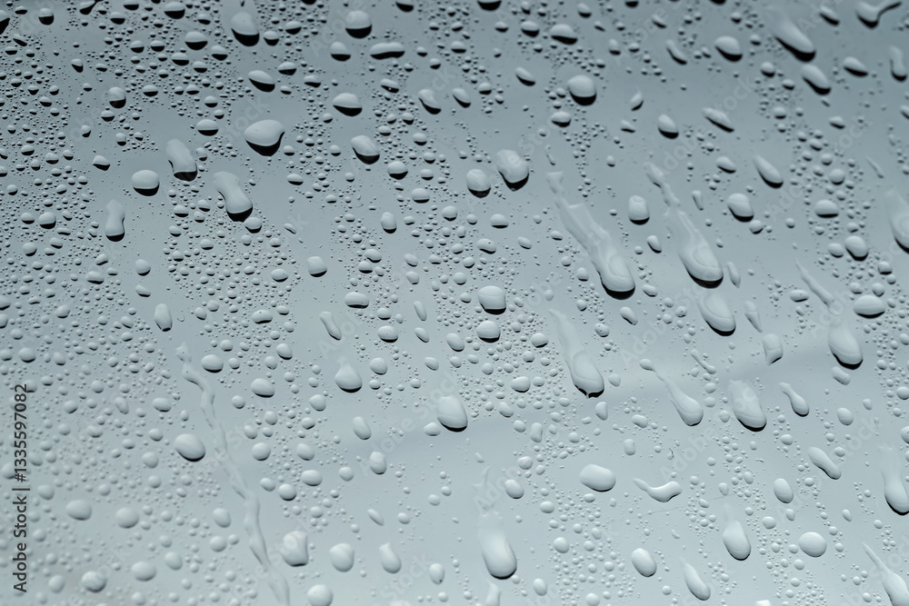 Water drops on grey glass surface, closeup Water drops on grey glass surface, closeup