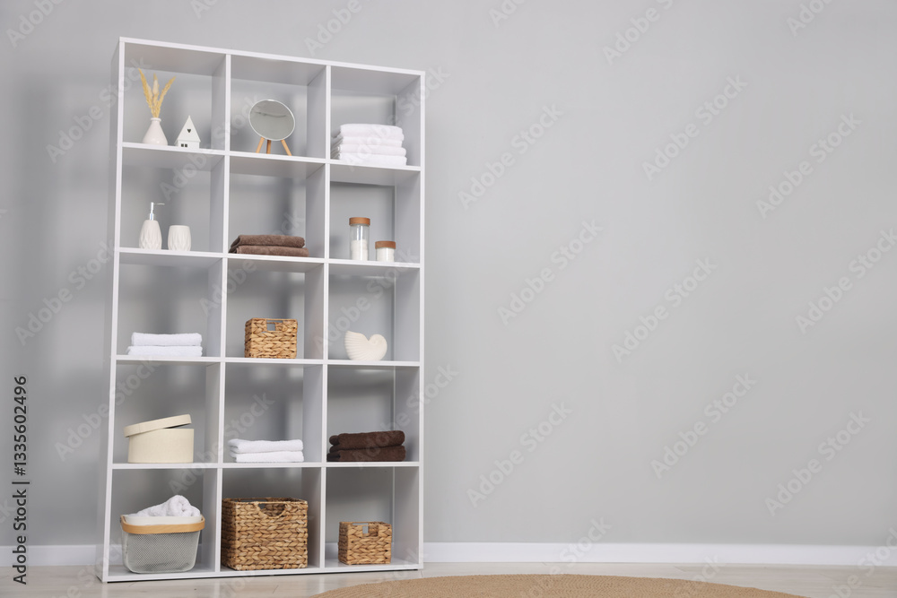 Shelving unit with decor near light grey wall. Space for text Shelving unit with decor near light grey wall. Space for text
