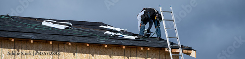 Foto New home construction site, roofing contractor (workman labor) putting down asph