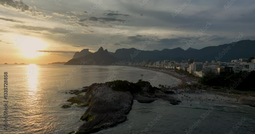 Aerial shot of people watching sunset on the rock by Ipanema Beach in Rio de Janeiro. Famous sunset city landmark Aerial shot of people watching sunset on the rock by Ipanema Beach in Rio de Janeiro. Famous sunset city landmark