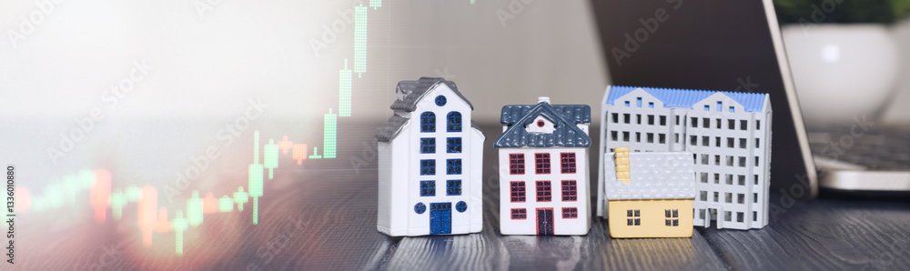 Miniature houses with stock market chart and laptop, symbolizing real estate investment, property market trends, and financial growth opportunities.