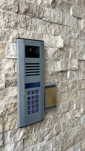 Fotografie Modern intercom and access control system mounted on a textured stone wall