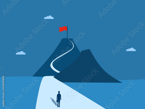 Businessman standing looking at victory flag on top of mountain in the distance