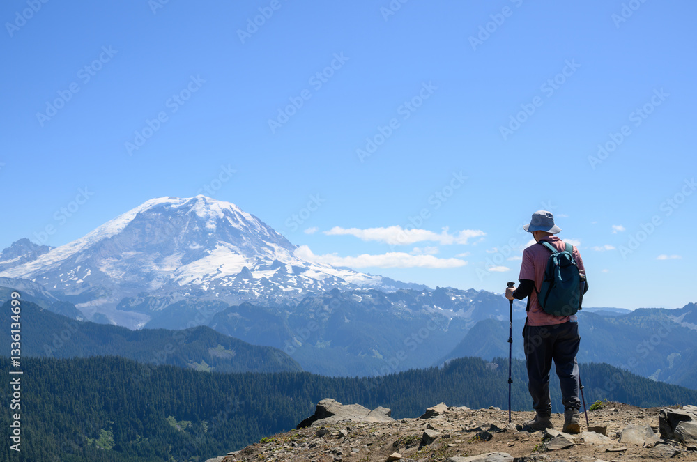 Man hiking Summit Lake trail. Mt Rainier in the distance. Mt Rainier National Park. Washington State.