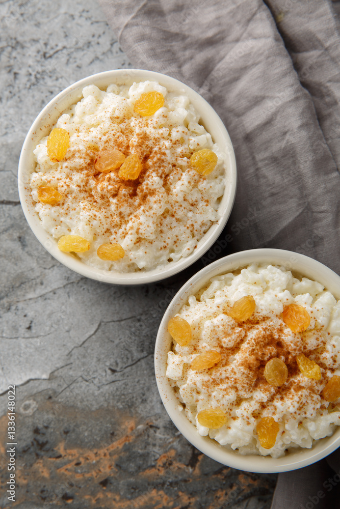 Old-Fashioned Rice Pudding is so creamy with the perfect texture and sweetness closeup on the bowl on the table. Vertical top view from above