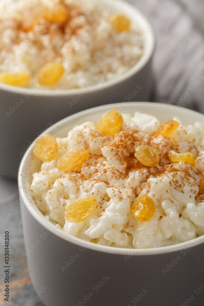 Old-Fashioned Rice Pudding is so creamy with the perfect texture and sweetness closeup on the bowl on the table. Vertical