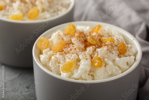 Obraz na płótnie Sweet rice pudding with cinnamon and raisins on top close-up in a ramekin on the table. Horizontal w salonie