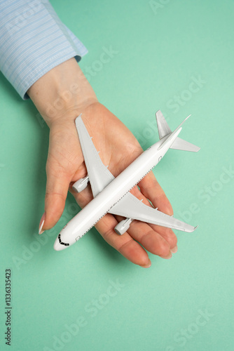 Obraz na płótnie An airline passenger plane in the palm of a woman's hand. Flight ticket booking concept. Flight reservations, travel planning, vacation preparations. Airline ticket sales, booking services, tourism w salonie