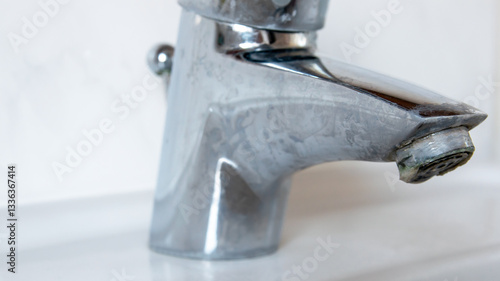 Metal tap with much water  limescale water in bathroom.