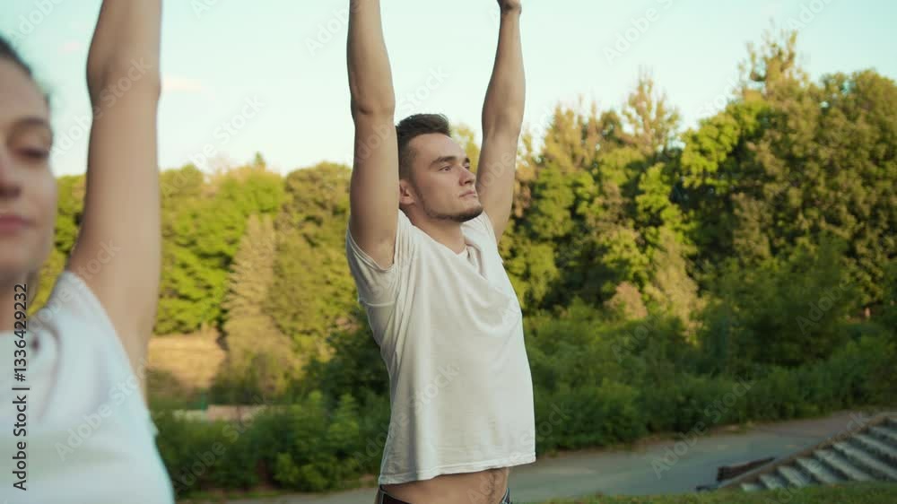 Young healthy fit caucasian couple practising spiritual exercises in meditation class at sunrise in the park. Yoga relaxation. Young healthy fit caucasian couple practising spiritual exercises in meditation class at sunrise in the park. Yoga relaxation.
