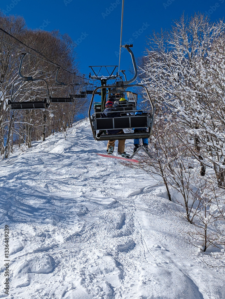 POV view from a ski chairlift on bright, sunny day.
