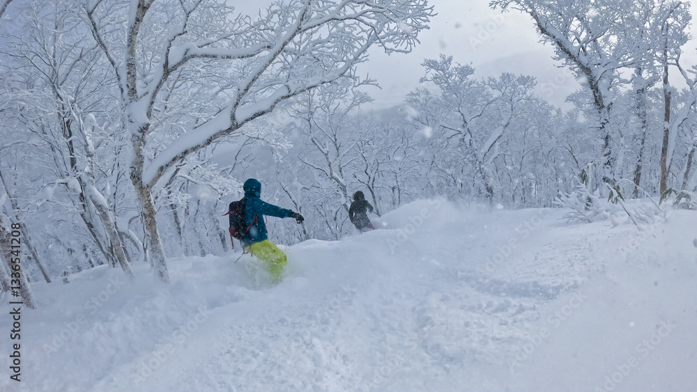 Two snowboarders carve through Rusutsu’s deep powder, weaving between snow laden trees in a serene, snow-covered forest. The untouched terrain and fresh lines offer an epic snowboarding adventure. Two snowboarders carve through Rusutsu’s deep powder, weaving between snow laden trees in a serene, snow-covered forest. The untouched terrain and fresh lines offer an epic snowboarding adventure.