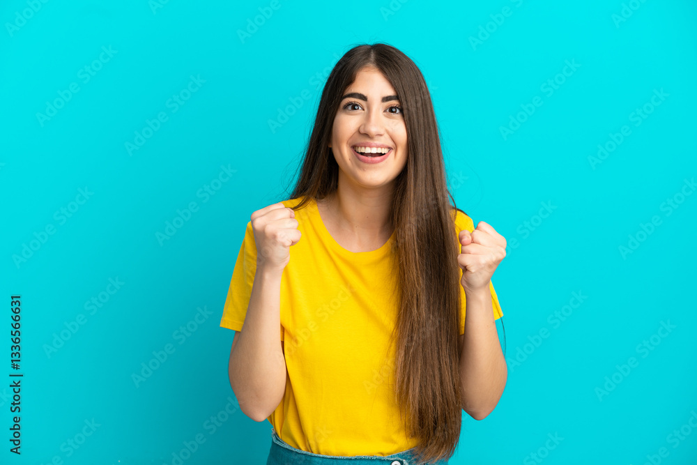 Young caucasian woman isolated on blue background celebrating a victory in winner position Young caucasian woman isolated on blue background celebrating a victory in winner position