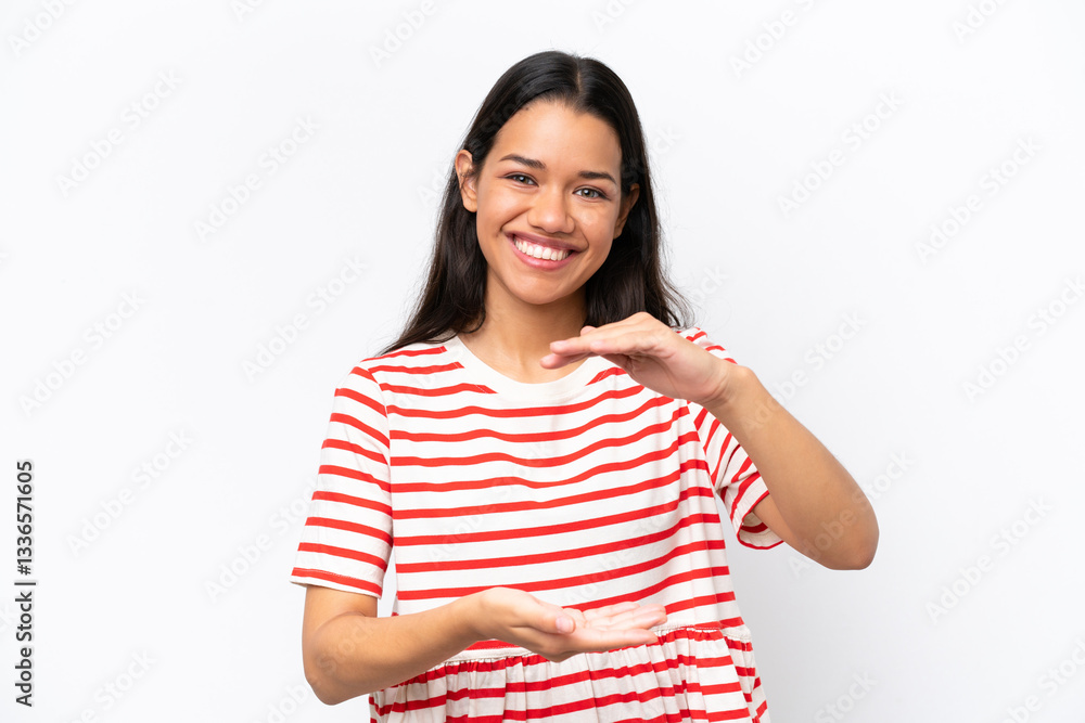 Young Colombian woman isolated on white background holding copyspace imaginary on the palm to insert an ad Young Colombian woman isolated on white background holding copyspace imaginary on the palm to insert an ad