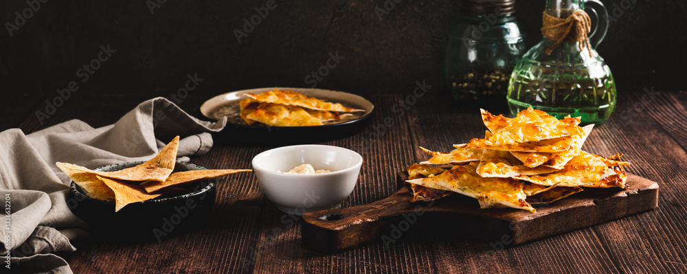 Crispy lavash chips with cheese and garlic on a board on the table web banner